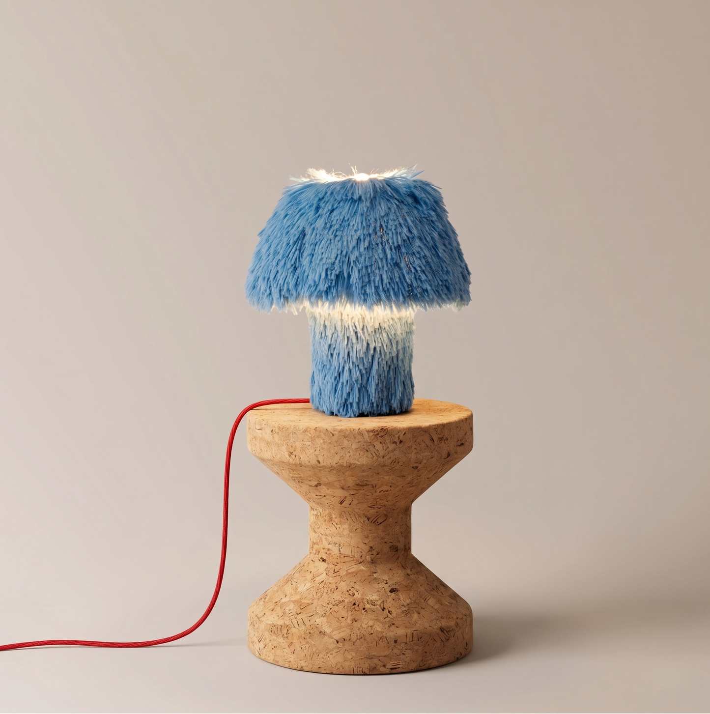 Cookie table lamp glowing on its jesmonite base, side view